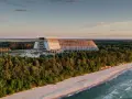 Ogromny, niedokończony hotel, który ma być największym hotelem w Polsce, góruje nad lasem i plażą o zachodzie słońca.