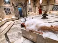 Kobieta w pianie w łaźni hammam. To tradycyjne tureckie łaźnie parowe, miejsce relaksu i oczyszczenia.