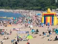 Tłum ludzi na plaży, dmuchany zamek, łodzie na wodzie – wakacje all inclusive Polska w pełni!