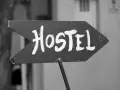 Strzałka z napisem "Hostel" wzywa podróżnych do taniego noclegu. To miejsce, gdzie poznasz innych wędrowców.