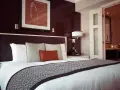 Przytulne łóżko w pokoju hotelowym, gdzie można odpocząć po podróży. To miejsce, gdzie nocleg jest komfortowy i przystępny cenowo, jak w dobrym hostelu.