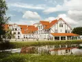 Malowniczy widok na narie resort & spa z łódką przy brzegu i odbiciem w wodzie.
