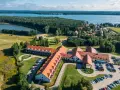 Malowniczy widok na Mikołajki Resort Spa z lotu ptaka, otoczony lasami i jeziorem. Idealne miejsce na relaks.