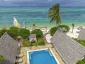 Zanzibar w lutym: słoneczna pogoda, turkusowe morze, palmy i urocze domki z krytymi dachami. Idealne miejsce na relaks.