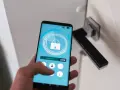 Smartfon z aplikacją hotelową pokazuje, jak się zameldować w hotelu, odblokowując drzwi.