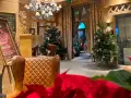 Przytulne wnętrze z choinkami i wygodnymi fotelami, idealne na pobyt z kolacją wigilijną.