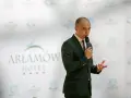 Mężczyzna w garniturze przemawia na tle logo Hotel Arłamów. Prawdopodobnie właściciel hotelu.
