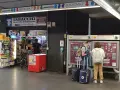 Przystanek autobusowy w Rzymie Ciampino. Ludzie kupują bilety i artykuły w sklepie.