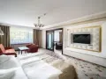 Wnętrze pokoju hotelowego z łóżkiem, kanapą i fotelem. Warto sprawdzić, ile pokoi ma Hotel Gołębiewski w Wiśle, by wybrać idealny dla siebie.