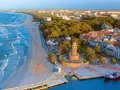 Malownicze miasta nad morzem z latarnią morską, plażą i portem.