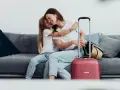 Mama i córka przytulają się na kanapie, obok walizka. Wszyscy, którzy chcą zameldować się w hotelu, mogą tu poczuć się jak w domu.