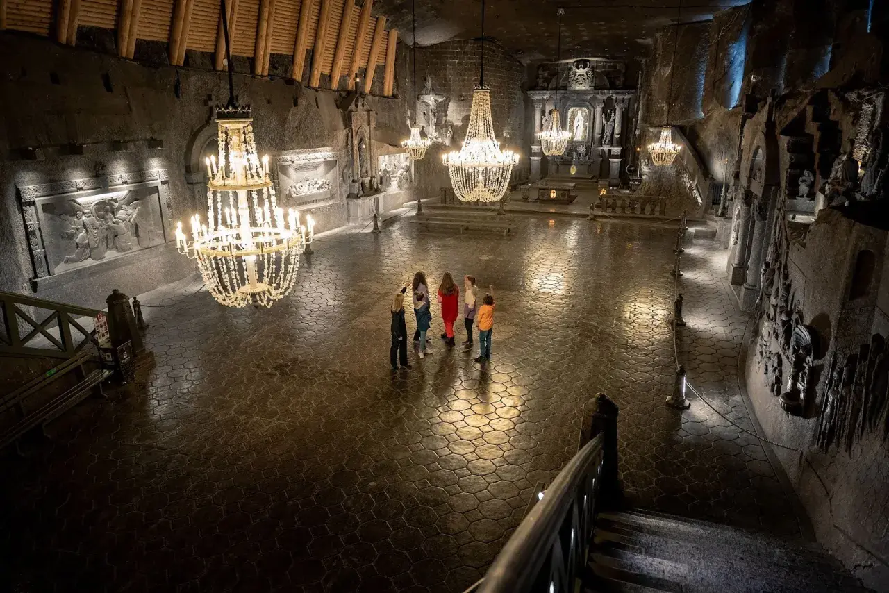 Rodzina zwiedza Kaplicę św. Kingi w Kopalni Soli Wieliczka. Bilety do kopalni warto kupić online.