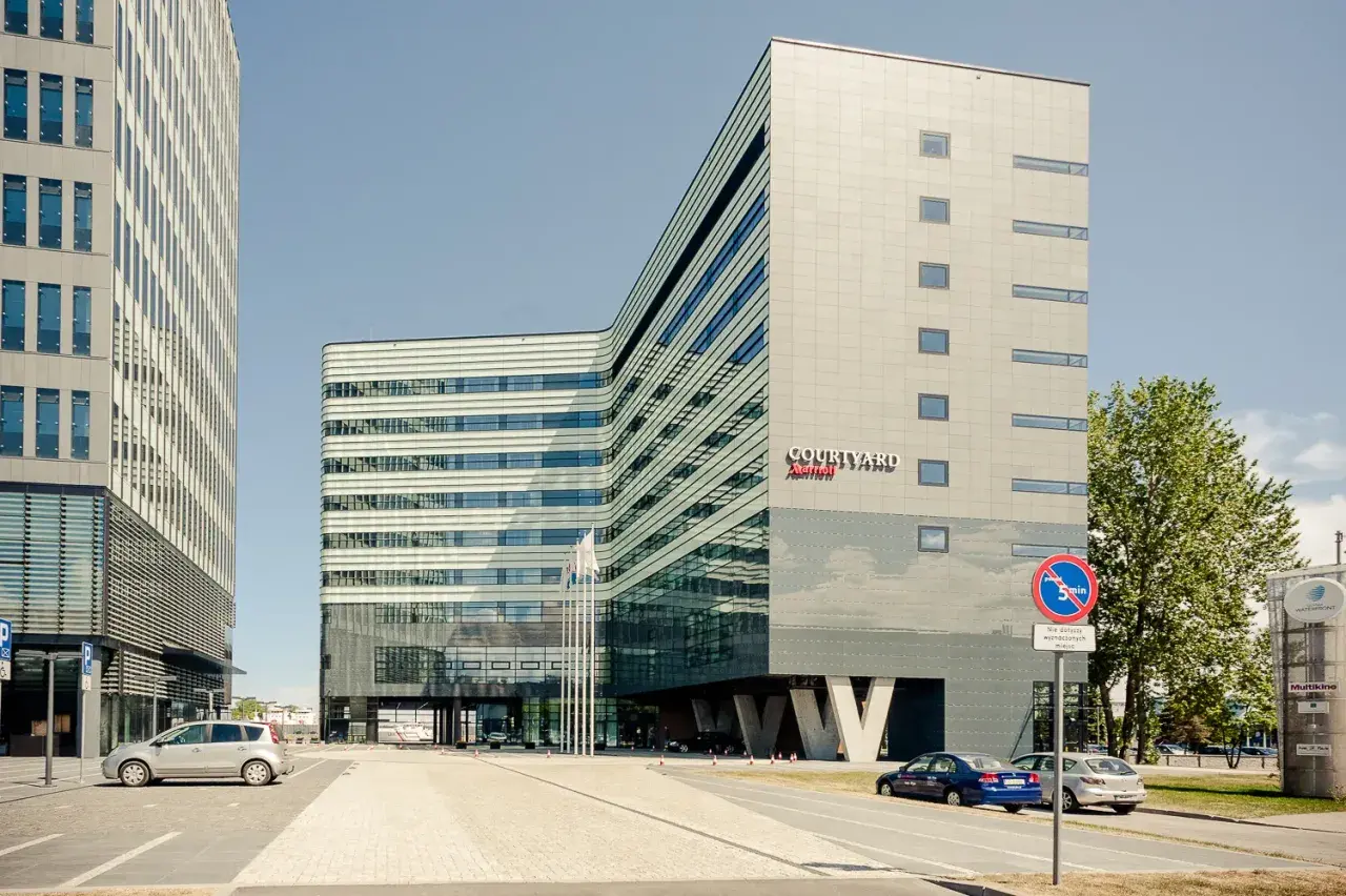 Nowoczesny budynek Courtyard by Marriott w Gdyni, z charakterystyczną, falistą fasadą i przeszklonym parterem.