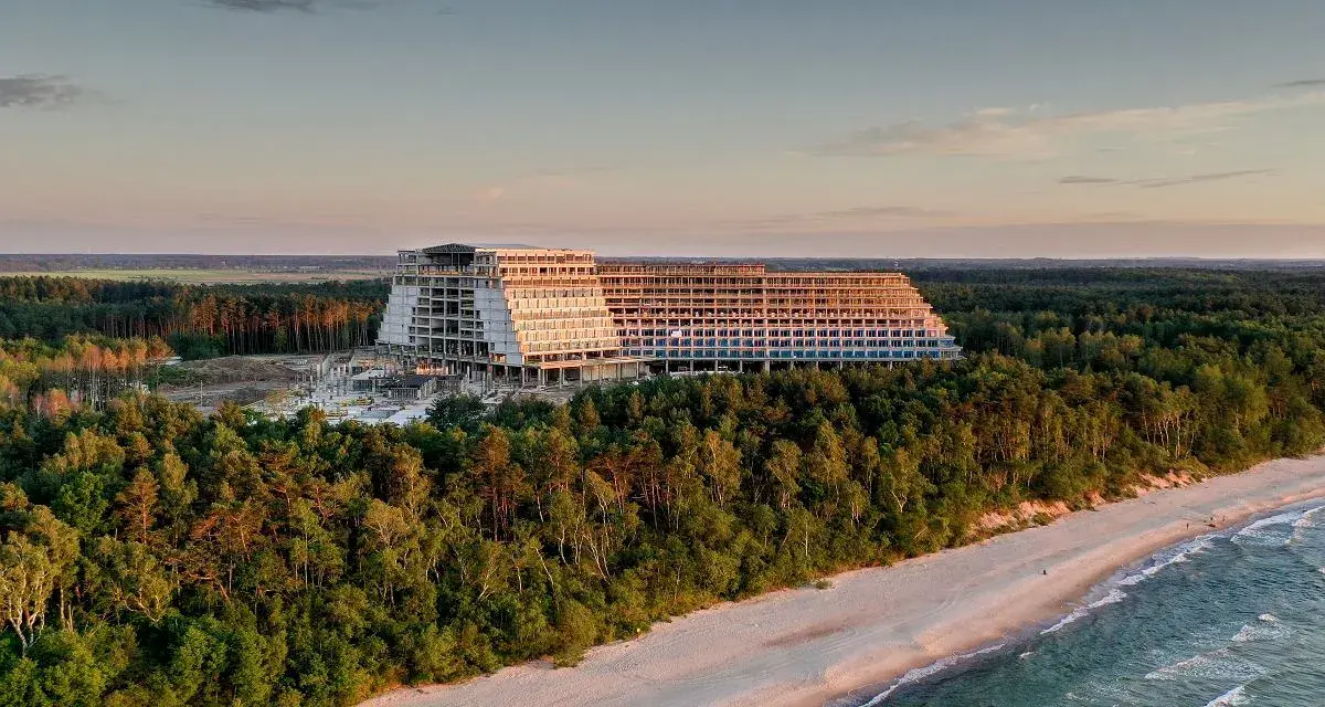 Ogromny, niedokończony hotel, który ma być największym hotelem w Polsce, góruje nad lasem i plażą o zachodzie słońca.