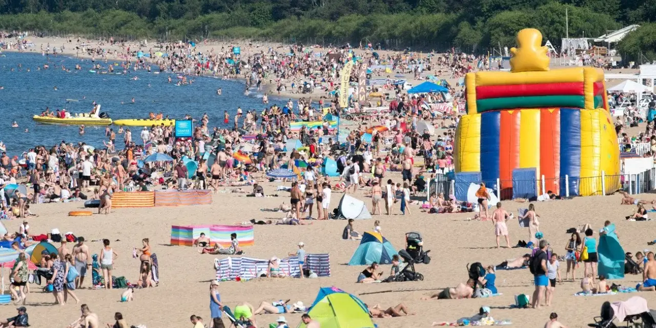 Tłum ludzi na plaży, dmuchany zamek, łodzie na wodzie – wakacje all inclusive Polska w pełni!
