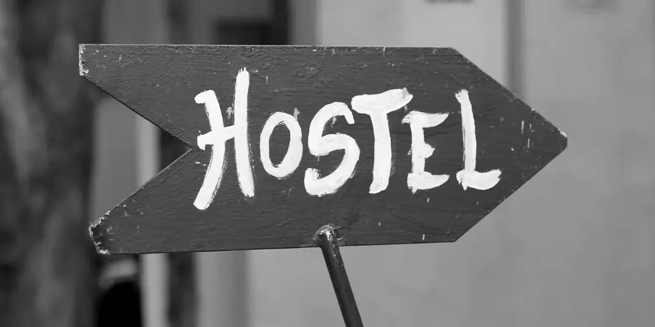 Strzałka z napisem "Hostel" wzywa podróżnych do taniego noclegu. To miejsce, gdzie poznasz innych wędrowców.