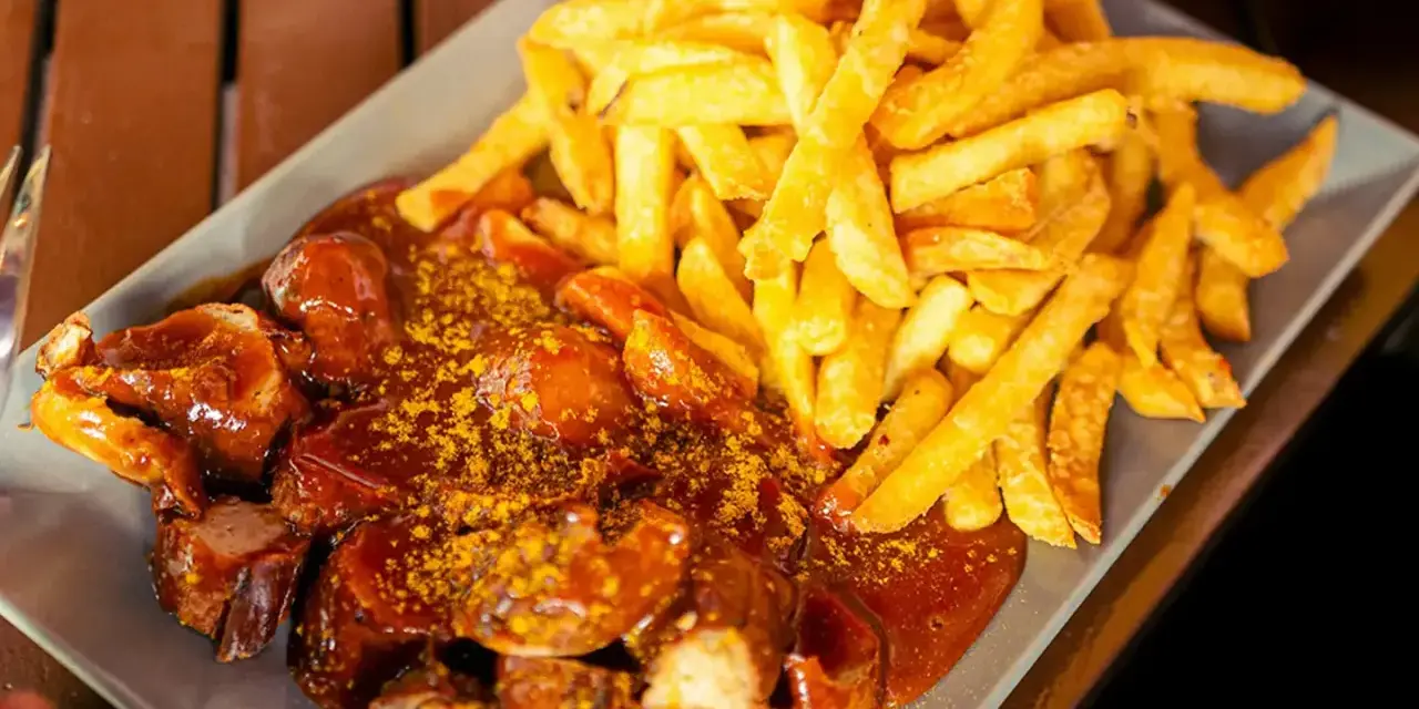 Currywurst z frytkami, klasyka, co zjeść w Berlinie. Pyszne danie na talerzu.