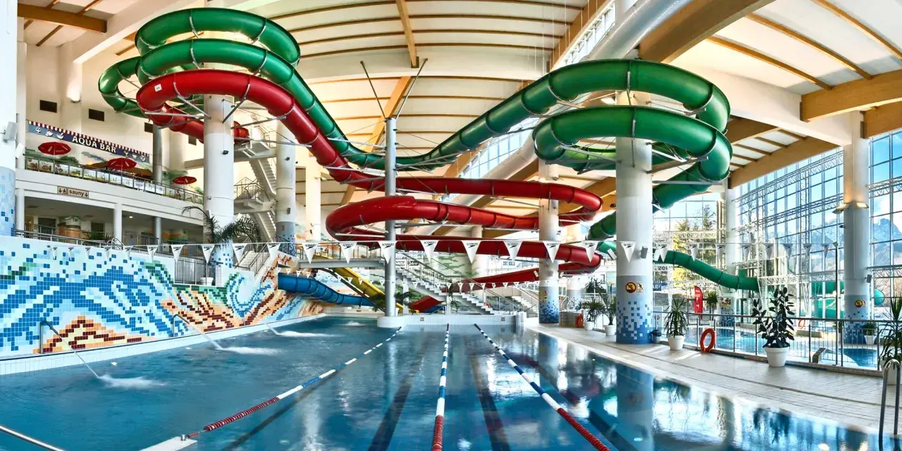Wesoły aquapark z hotelem oferuje zjeżdżalnie w kolorach czerwonym i zielonym, basen i mnóstwo zabawy.