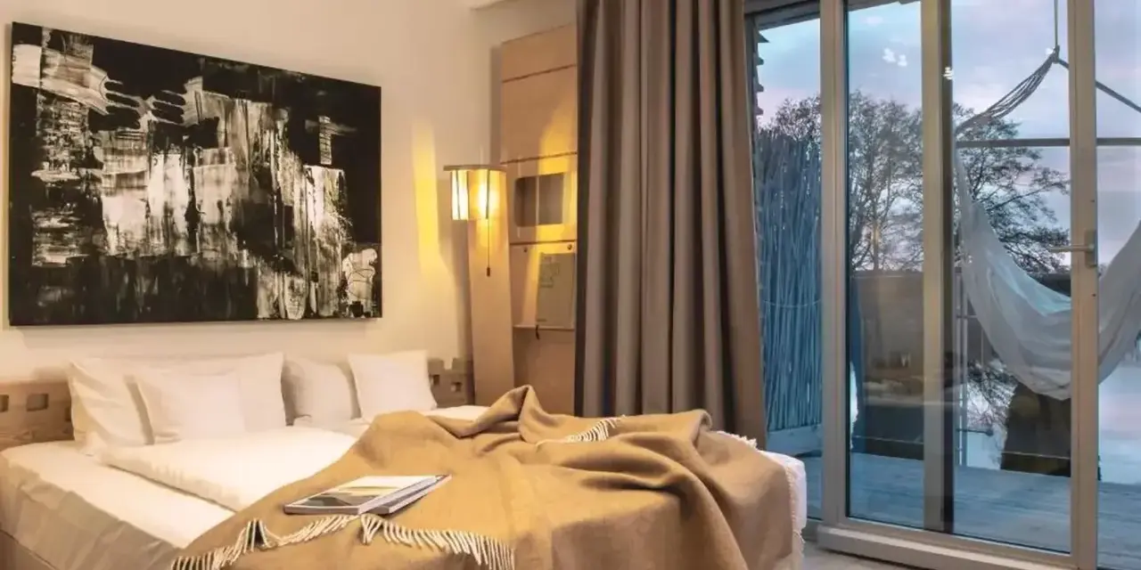 Nowe spojrzenie na to, co oznacza hotel dla dorosłych: przytulna sypialnia z widokiem na naturę i hamak.