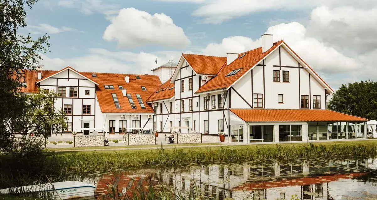 Malowniczy widok na narie resort & spa z łódką przy brzegu i odbiciem w wodzie.
