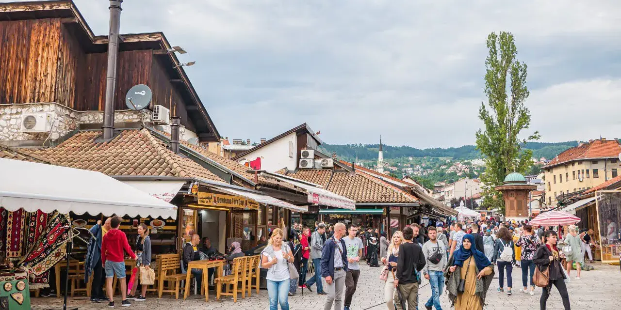 Tłoczny bazar w Sarajewie, idealne miejsce na bośnia i hercegowina wakacje. Ludzie spacerują, kupują pamiątki i jedzą w kawiarniach.