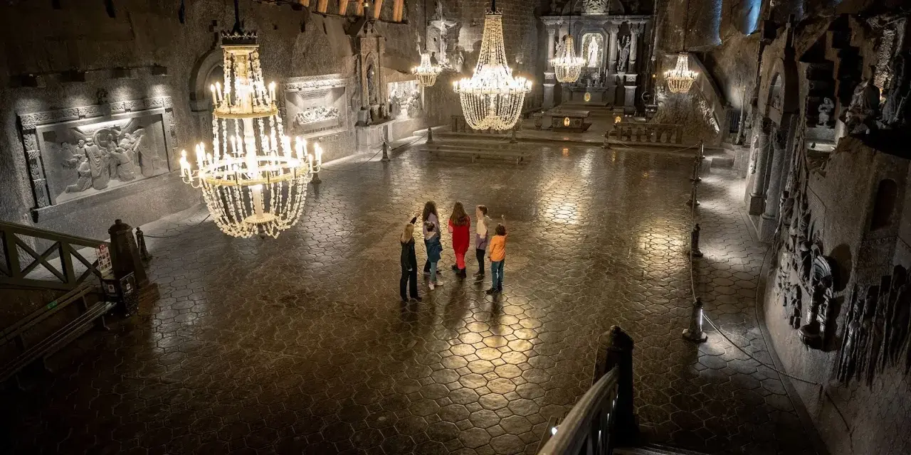 Rodzina zwiedza Kaplicę św. Kingi w Kopalni Soli Wieliczka. Bilety do kopalni warto kupić online.