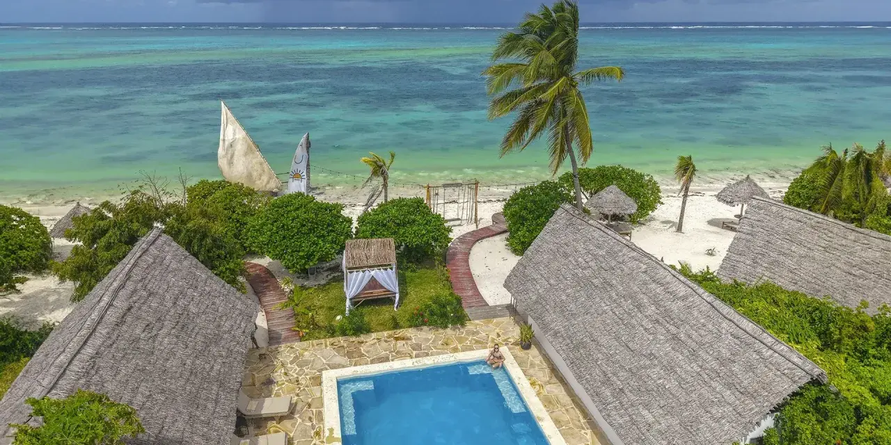 Zanzibar w lutym: słoneczna pogoda, turkusowe morze, palmy i urocze domki z krytymi dachami. Idealne miejsce na relaks.