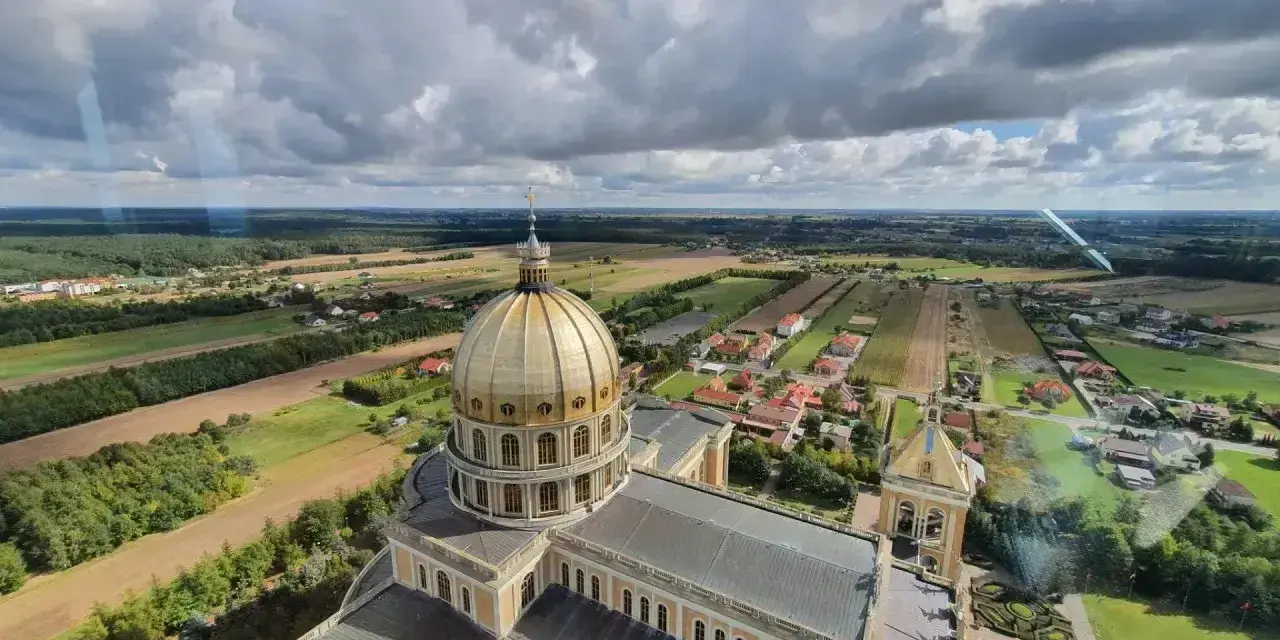 Bazylika w Licheniu z lotu ptaka. Widok na złotą kopułę i okoliczne pola. Sprawdź licheń cennik atrakcji.