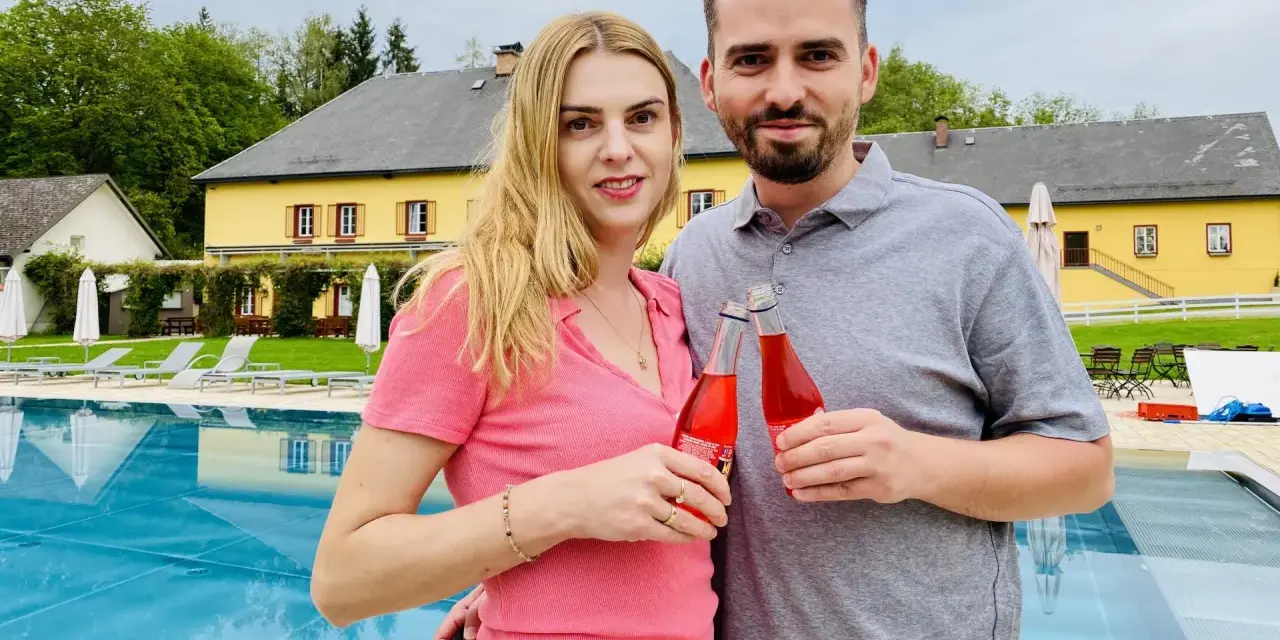 Para z napojami przy basenie. Taki nocleg tranzytowy to idealny przystanek w podróży.