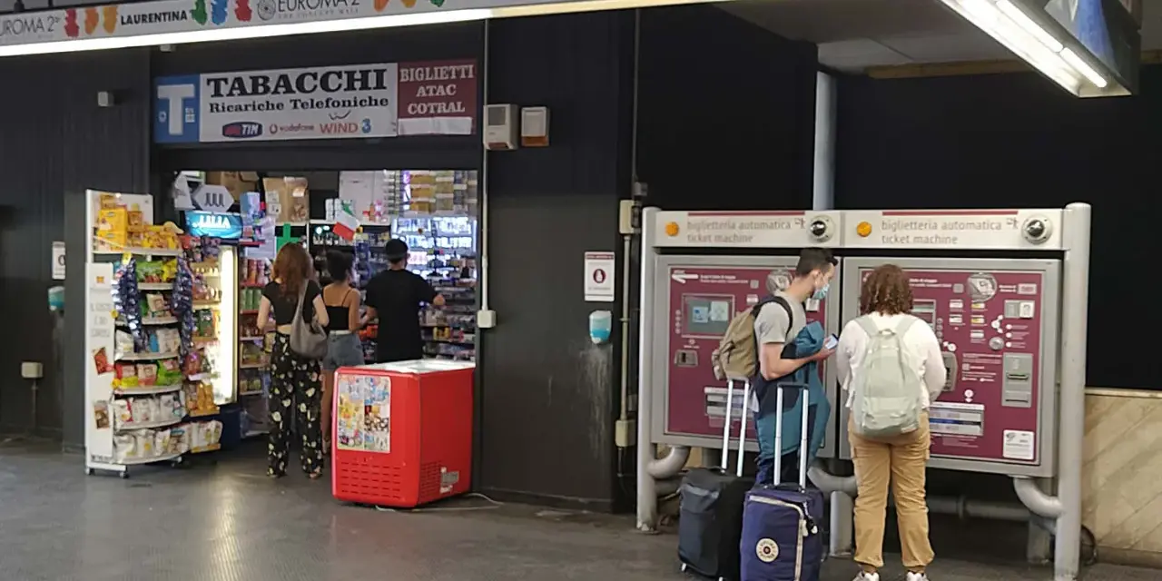 Przystanek autobusowy w Rzymie Ciampino. Ludzie kupują bilety i artykuły w sklepie.
