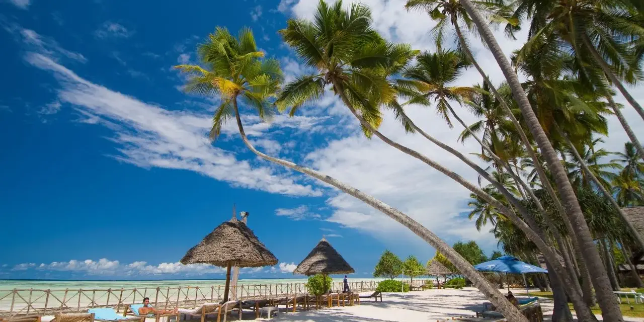 Rajska plaża na Zanzibarze, palmy, leżaki i turkusowe morze. Zastanawiasz się, ile się leci na Zanzibar? To podróż marzeń!