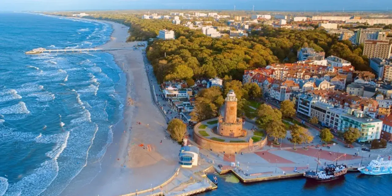 Malownicze miasta nad morzem z latarnią morską, plażą i portem.