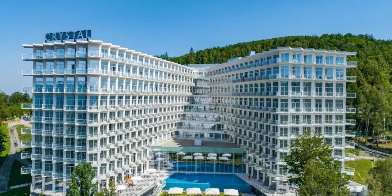 Nowoczesny hotel Crystal w Wiśle, z basenem i tarasami, otoczony zielenią. Idealne miejsce na górski relaks w Wiśle Mountain Spa.