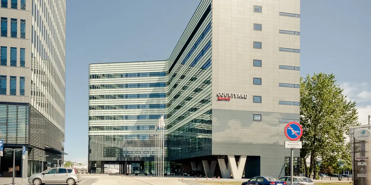Nowoczesny budynek Courtyard by Marriott w Gdyni, z charakterystyczną, falistą fasadą i przeszklonym parterem.