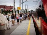 Ludzie na peronie czekają na pociąg SKM w Warszawie. Wszyscy mają bilety i gotowi są do podróży.