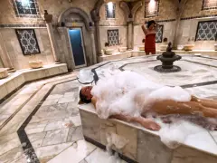 Kobieta w pianie w łaźni hammam. To tradycyjne tureckie łaźnie parowe, miejsce relaksu i oczyszczenia.