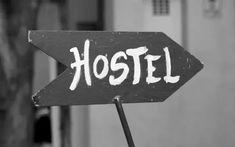Strzałka z napisem "Hostel" wzywa podróżnych do taniego noclegu. To miejsce, gdzie poznasz innych wędrowców.