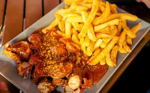 Currywurst z frytkami, klasyka, co zjeść w Berlinie. Pyszne danie na talerzu.
