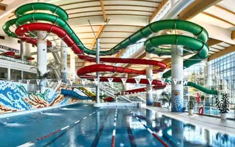 Wesoły aquapark z hotelem oferuje zjeżdżalnie w kolorach czerwonym i zielonym, basen i mnóstwo zabawy.