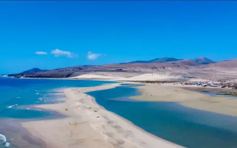Piękne plaże Sotavento z turkusową wodą i piaszczystymi wydmami, w tle góry.