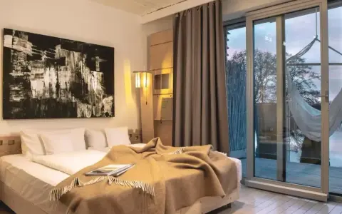 Nowe spojrzenie na to, co oznacza hotel dla dorosłych: przytulna sypialnia z widokiem na naturę i hamak.