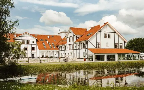 Malowniczy widok na narie resort & spa z łódką przy brzegu i odbiciem w wodzie.