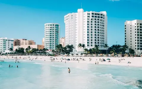 Piękna plaża z turkusową wodą i hotelami w tle. Zastanawiasz się, ile się leci do Meksyku, by tu dotrzeć?