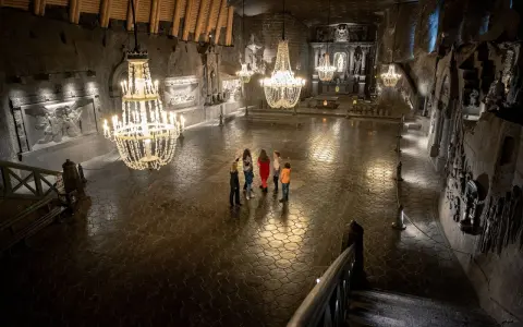 Rodzina zwiedza Kaplicę św. Kingi w Kopalni Soli Wieliczka. Bilety do kopalni warto kupić online.