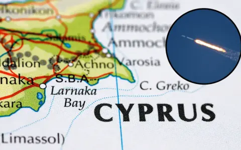 Mapa Cypru z zaznaczonym lotniskiem w Larnace. W okręgu widoczny start rakiety kosmicznej.