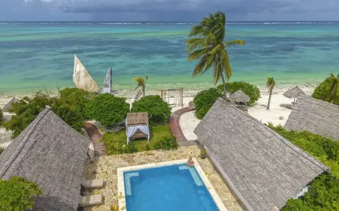 Zanzibar w lutym: słoneczna pogoda, turkusowe morze, palmy i urocze domki z krytymi dachami. Idealne miejsce na relaks.