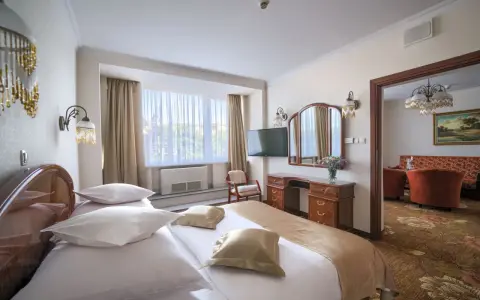 Przytulny pokój hotelowy w Białymstoku z wygodnym łóżkiem, toaletką i widokiem na salon.