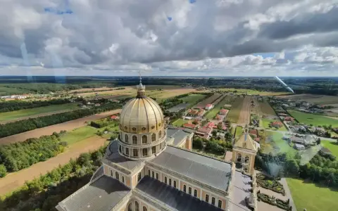 Bazylika w Licheniu z lotu ptaka. Widok na złotą kopułę i okoliczne pola. Sprawdź licheń cennik atrakcji.