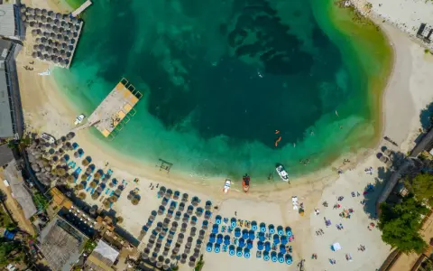 Widok z lotu ptaka na **Albania plaże** z turkusową wodą, leżakami i parasolami.