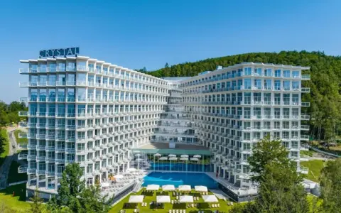 Nowoczesny hotel Crystal w Wiśle, z basenem i tarasami, otoczony zielenią. Idealne miejsce na górski relaks w Wiśle Mountain Spa.